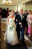 Martina being escorted down the aisle by her father
